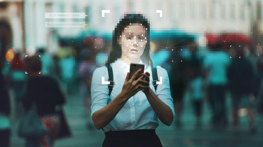 A woman uses facial recognition to confirm her identity. KYC procedures use technology to help identify clients.