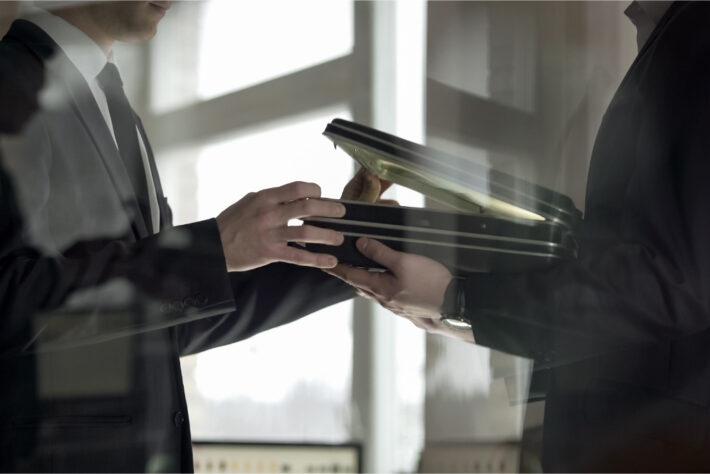 Two businessmen open a spooky briefcase – implying dodgy deals